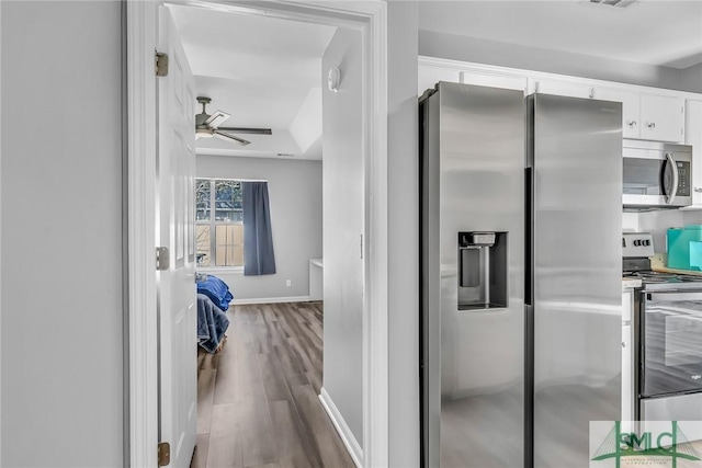 kitchen featuring hardwood / wood-style floors, ceiling fan, white cabinetry, and stainless steel appliances