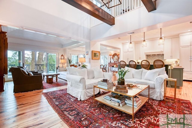 living room featuring light hardwood / wood-style flooring and a high ceiling