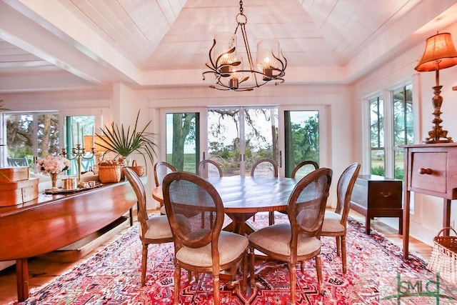 dining area with a notable chandelier, lofted ceiling, and hardwood / wood-style flooring