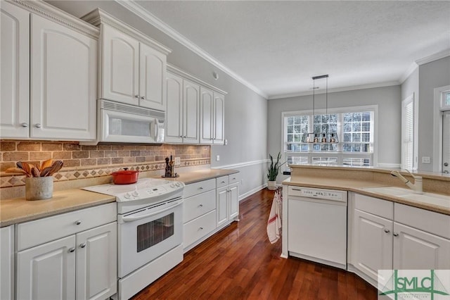 kitchen featuring white appliances, hanging light fixtures, white cabinetry, and crown molding