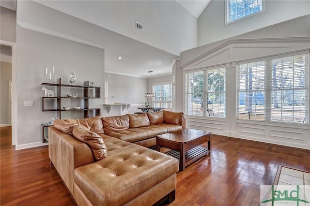 living room featuring hardwood / wood-style floors, a high ceiling, and ornamental molding