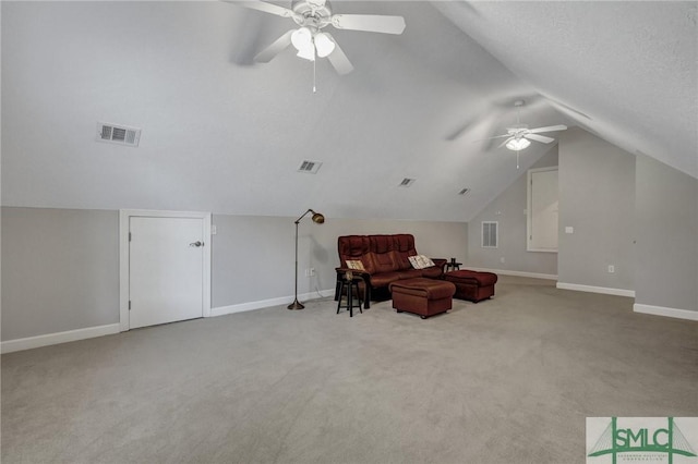 living area with light carpet, vaulted ceiling, ceiling fan, and a textured ceiling