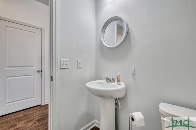 bathroom featuring hardwood / wood-style flooring and toilet