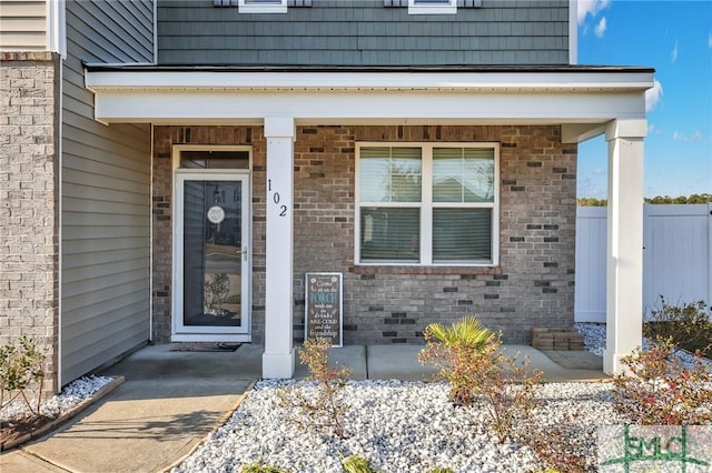 view of exterior entry featuring covered porch