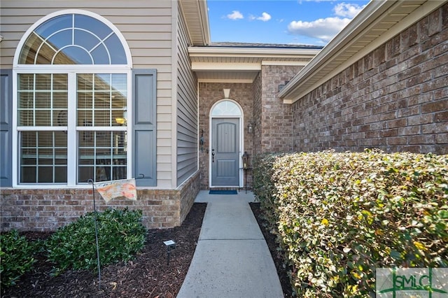 doorway to property featuring brick siding