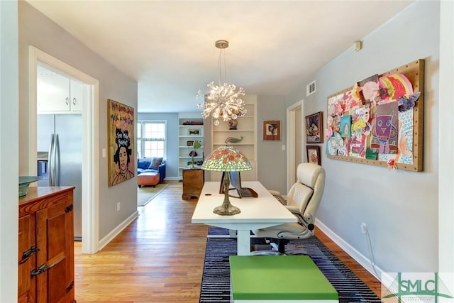 dining room with a notable chandelier and light hardwood / wood-style floors