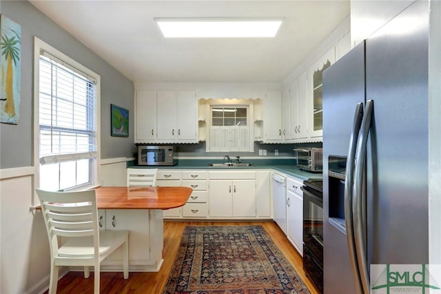 kitchen with white cabinetry, stainless steel appliances, dark hardwood / wood-style floors, and sink