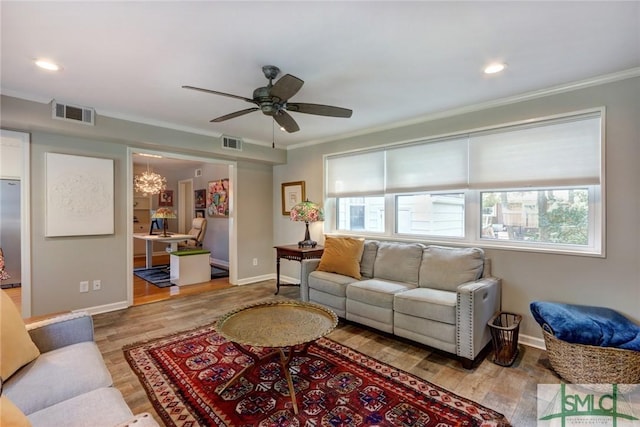 living room featuring hardwood / wood-style flooring, crown molding, and a healthy amount of sunlight