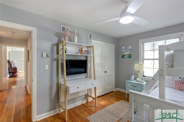 bedroom with a closet, ceiling fan, and light hardwood / wood-style flooring