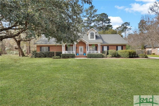 new england style home with brick siding, a porch, and a front yard