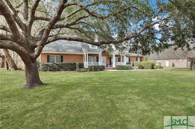 ranch-style house with covered porch, brick siding, and a front lawn