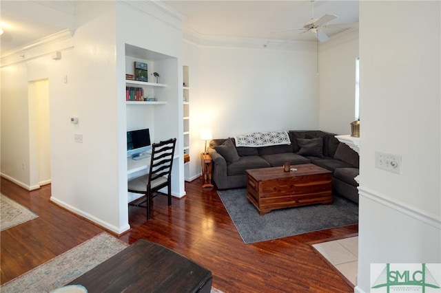 living room with dark hardwood / wood-style flooring, ceiling fan, crown molding, and built in shelves