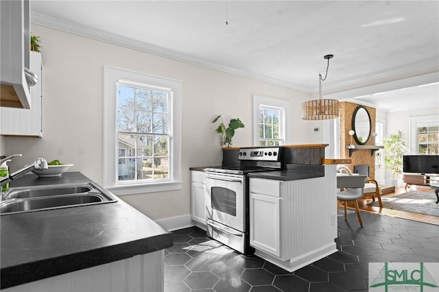 kitchen with dark countertops, pendant lighting, stainless steel range with electric cooktop, white cabinetry, and a sink