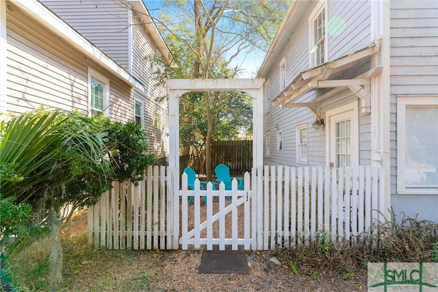 view of side of home featuring fence and a gate