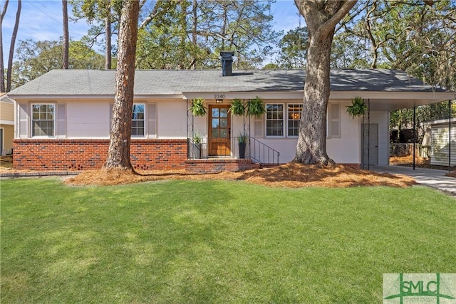 ranch-style home featuring brick siding, a front yard, an attached carport, and driveway