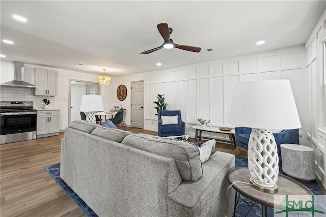 living area featuring recessed lighting, ceiling fan, wood finished floors, and visible vents