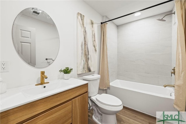 bathroom featuring toilet, wood finished floors, vanity, and shower / bath combo