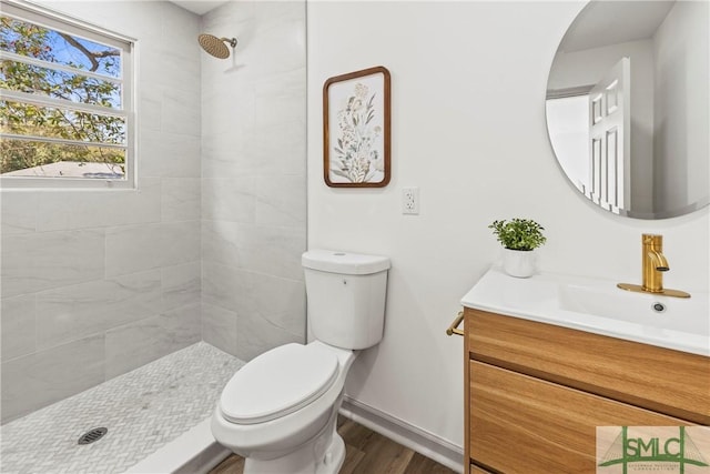 full bathroom with baseboards, a shower stall, vanity, wood finished floors, and toilet