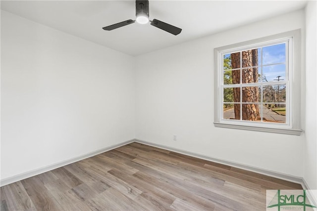 empty room featuring ceiling fan, light wood-style floors, and baseboards