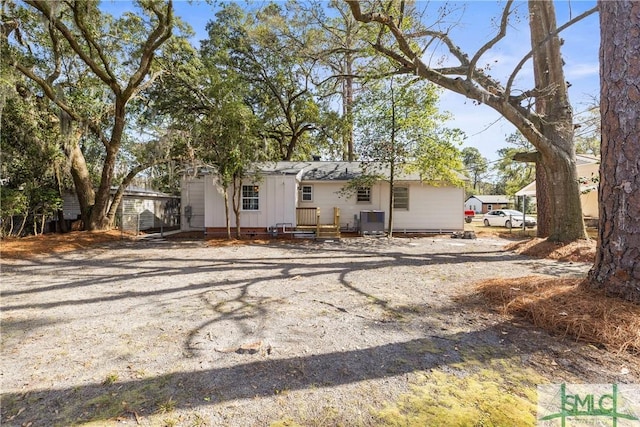 view of front facade with driveway and central AC