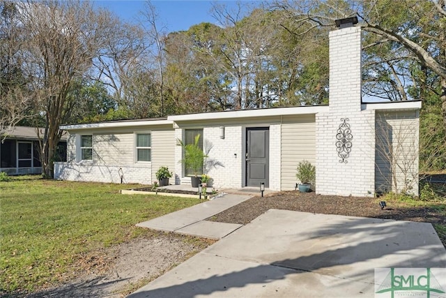 view of front of home with a front yard and a patio