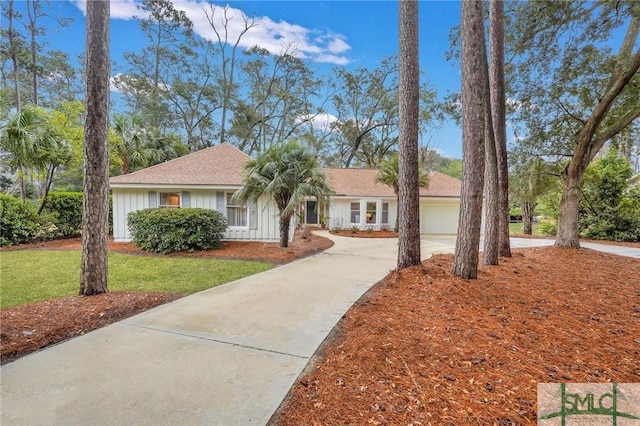 ranch-style home featuring a front lawn, board and batten siding, and driveway