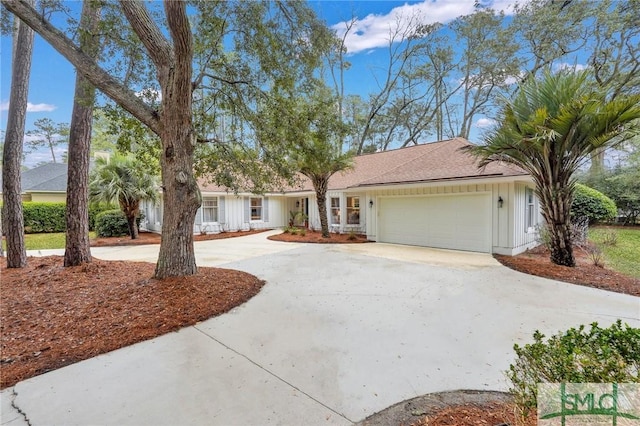 ranch-style house with an attached garage, board and batten siding, and concrete driveway