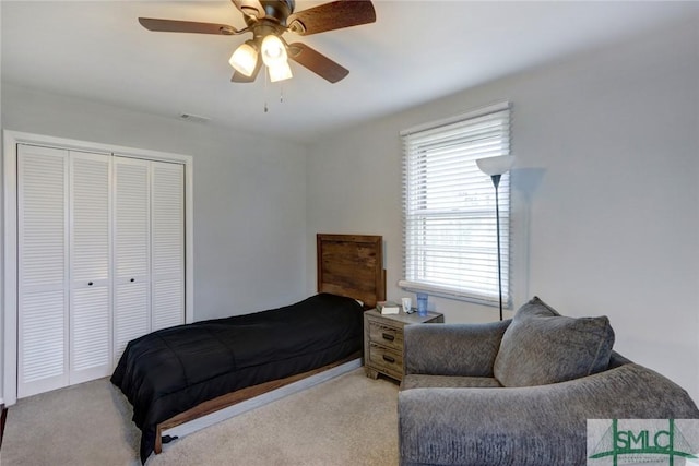 bedroom featuring visible vents, a closet, light carpet, and ceiling fan