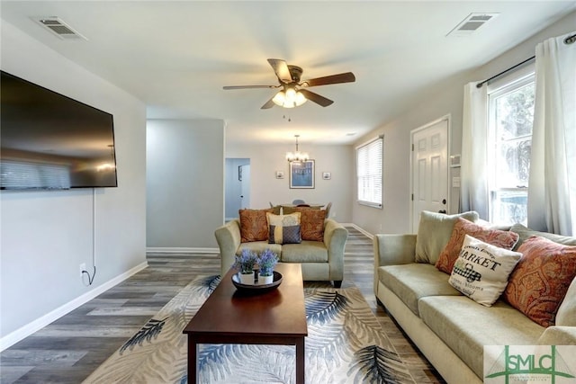 living area with baseboards, visible vents, and dark wood-type flooring