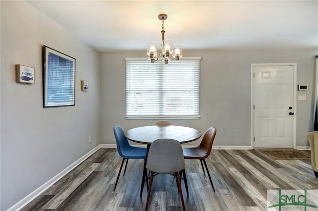 dining space featuring baseboards, a notable chandelier, and dark wood-style flooring