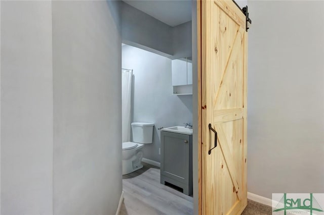 bathroom with baseboards, vanity, and toilet