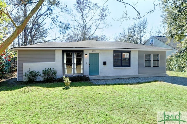 ranch-style home featuring brick siding and a front yard