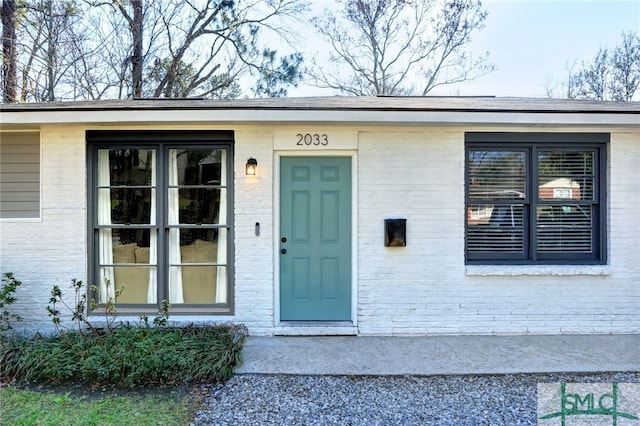 property entrance featuring brick siding