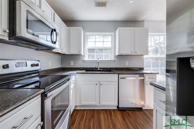 kitchen with a sink, appliances with stainless steel finishes, and white cabinets