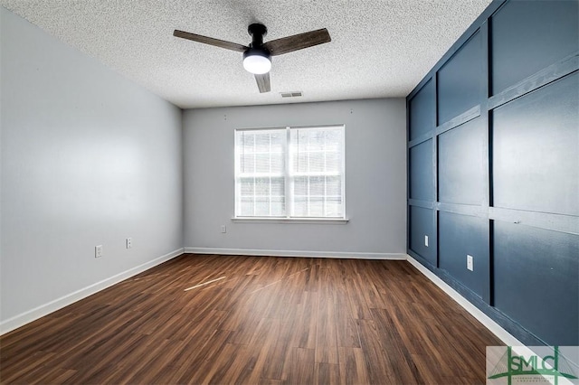 unfurnished bedroom with dark wood finished floors, visible vents, baseboards, and a textured ceiling