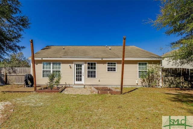 back of property featuring a vegetable garden, a lawn, and a fenced backyard