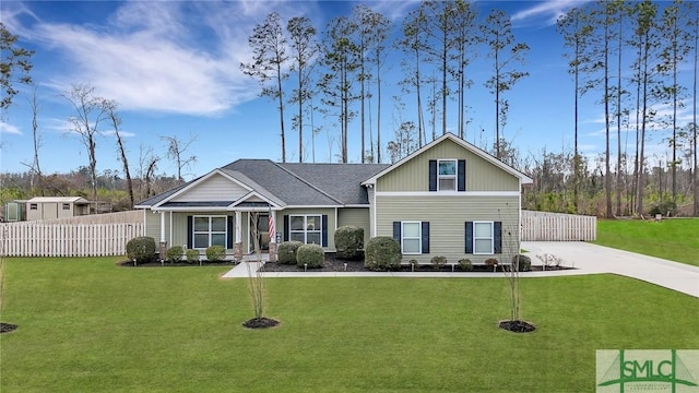 view of front of house featuring driveway, fence, and a front lawn