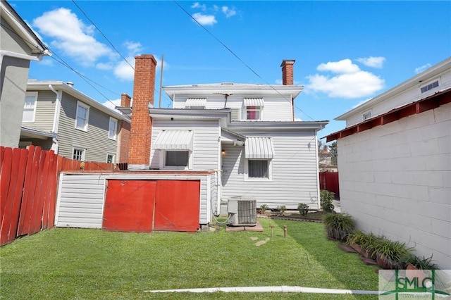 back of house with central AC, fence, a chimney, and a lawn