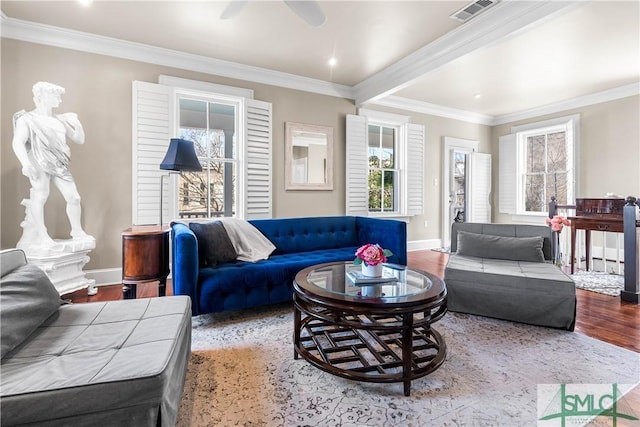 living area with light wood-type flooring, baseboards, visible vents, and crown molding