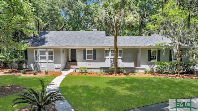 ranch-style house with a shingled roof, a front lawn, and stucco siding