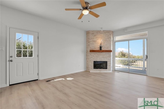 unfurnished living room featuring a fireplace, visible vents, light wood-style floors, a ceiling fan, and baseboards