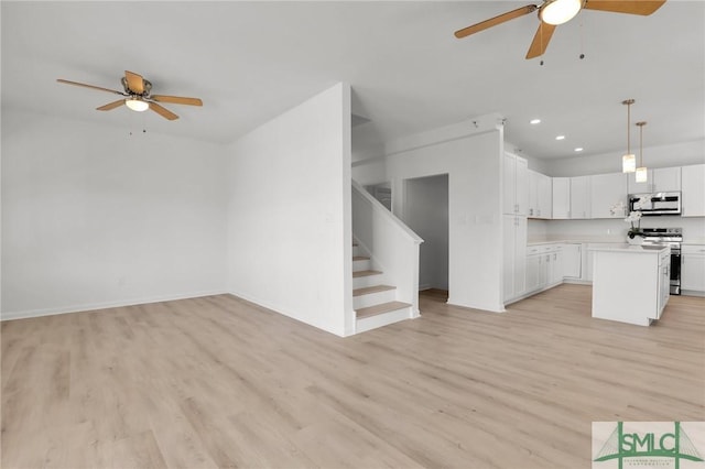 kitchen with a center island, white cabinetry, light countertops, and open floor plan