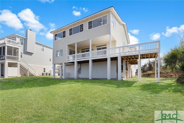 rear view of property with a lawn and a wooden deck