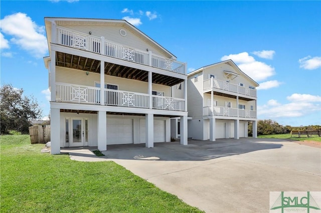 view of front facade with driveway, a front lawn, an attached garage, and a balcony