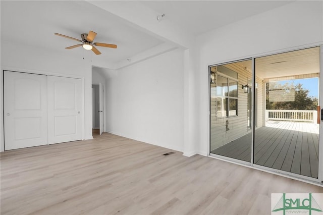 unfurnished bedroom with light wood-style flooring, visible vents, a ceiling fan, access to outside, and a closet