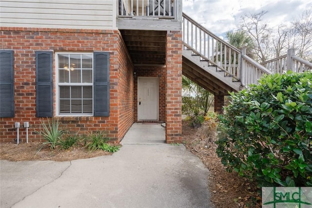 view of exterior entry featuring brick siding