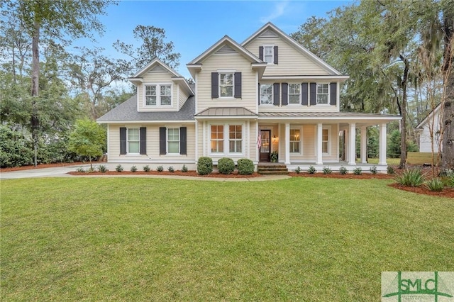 view of front of property with covered porch, a standing seam roof, metal roof, and a front yard