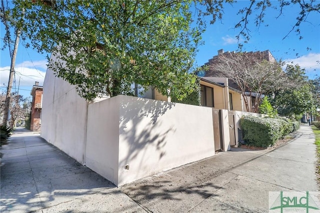 view of property exterior featuring fence and stucco siding