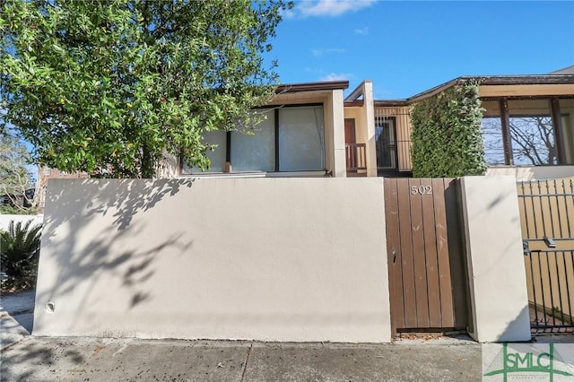 view of front of home featuring a fenced front yard, a gate, and stucco siding