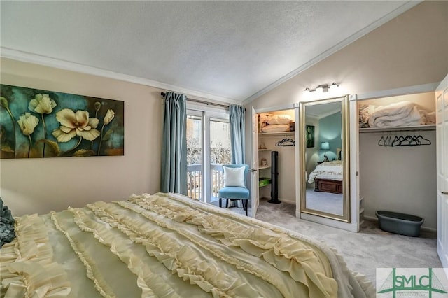 carpeted bedroom featuring lofted ceiling, ornamental molding, a textured ceiling, and a walk in closet